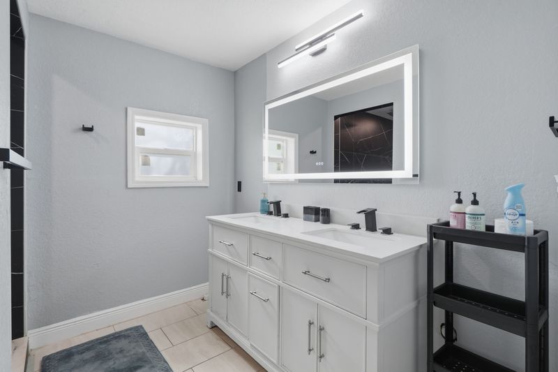 Bathroom with double-sink vanity and tiled shower